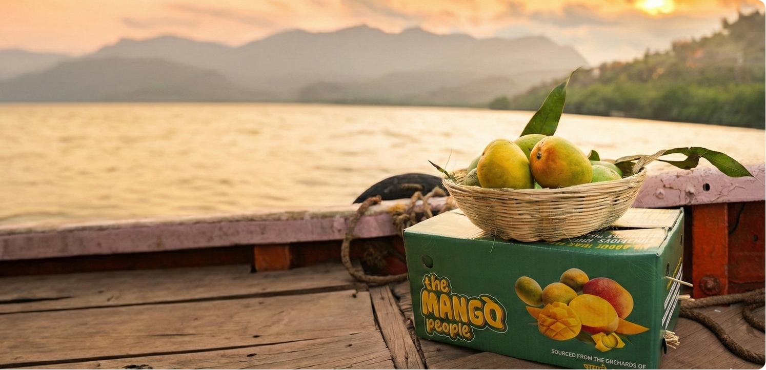 Fruit basket with mangoes on a wooden platform by a lake with mountains in the background